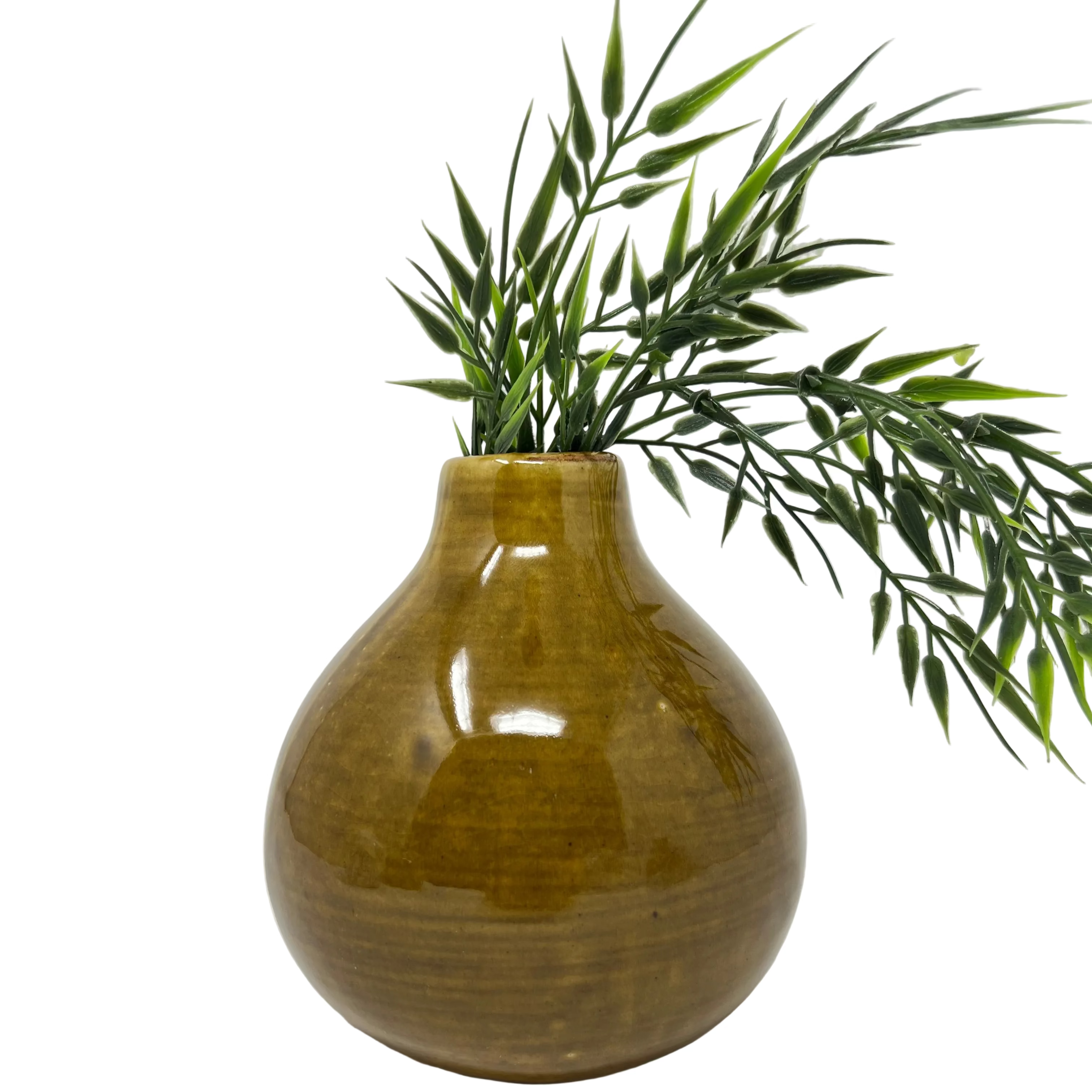 A glossy, rounded ceramic vase in a warm mustard-yellow glaze, styled with green artificial palm leaves against a plain white studio background.