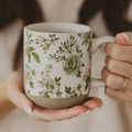 Person holding a mug with floral pattern